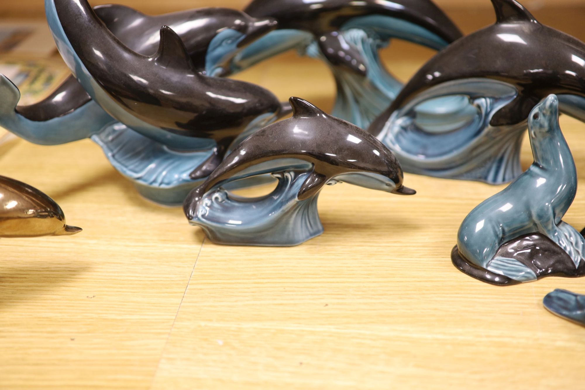 Six Poole pottery dolphins together with two similar seals and an otter